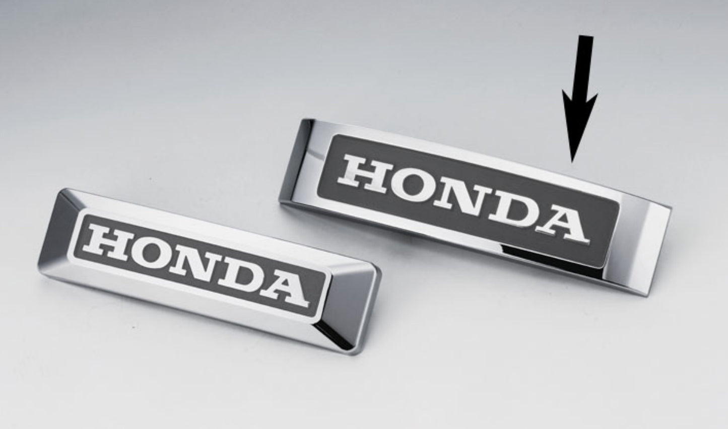 Two Honda emblems on a light gray background