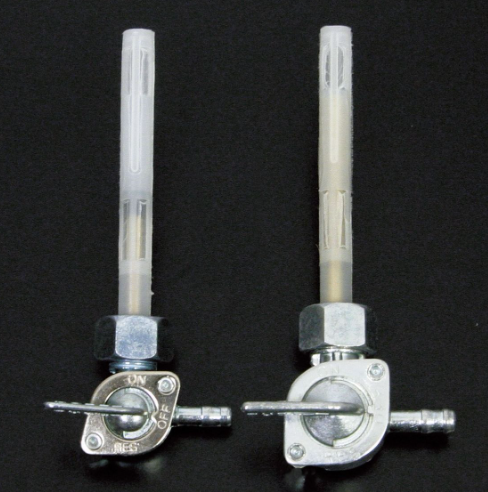 Two metal valve stems with knobs on a black background