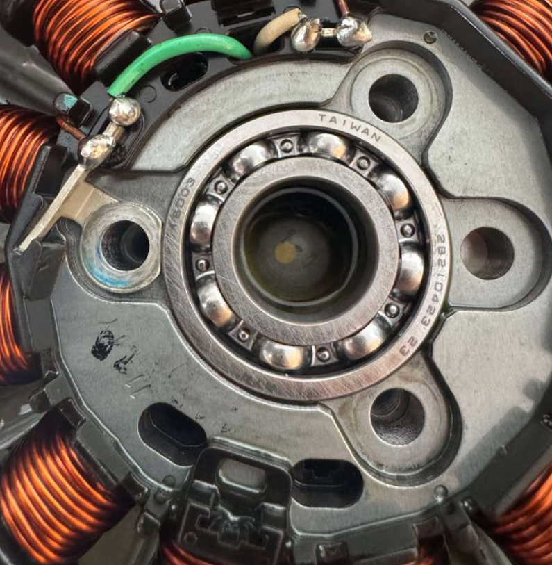 Close-up of a mechanical component with copper coils and bearings