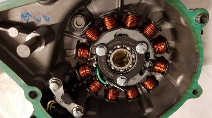 Close-up of a mechanical component with copper coils and metal parts on a white background