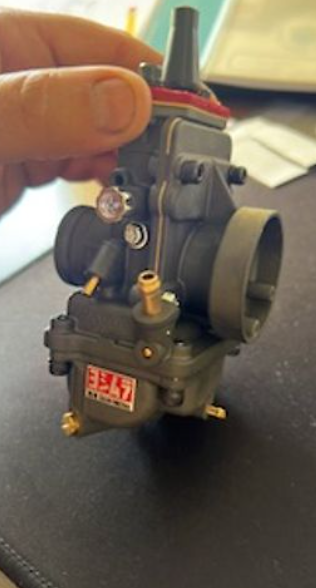 Mechanical component with visible branding on a dark surface