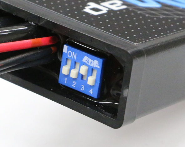 Close-up of a electronic component with wiring and labeled terminals on a white background