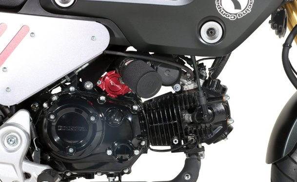Close-up of a motorcycle engine with visible branding on a white background