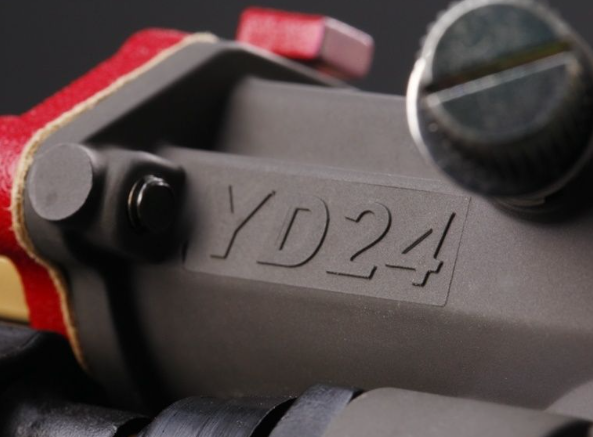 Close-up of a tool with 'YD24' engraving on a dark background