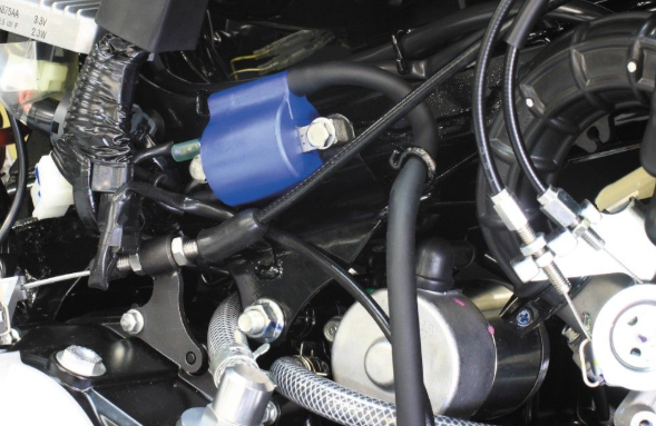 Close-up of a motorcycle engine with a blue connector.