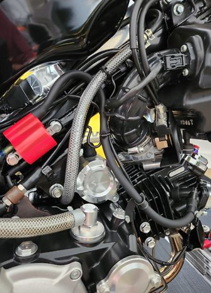 Close-up of a motorcycle engine with visible wiring and components.
