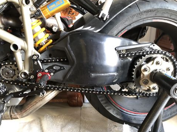 Close-up of a motorcycle chain and sprocket system.