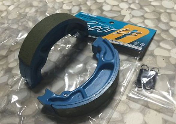 Blue brake shoe with packaging on a reflective surface