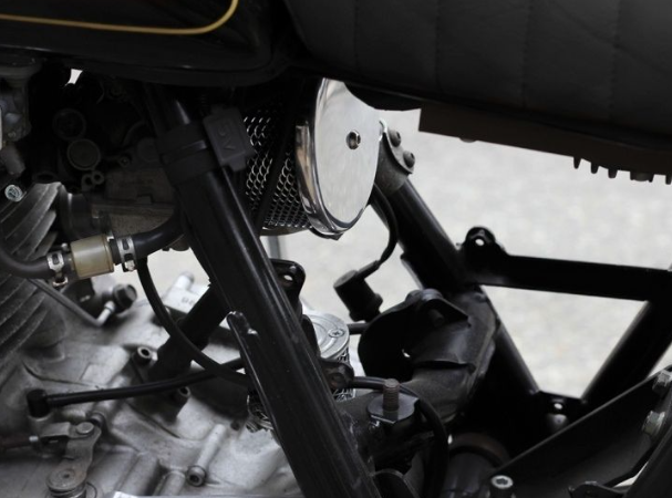 Close-up of a motorcycle engine and exhaust system.