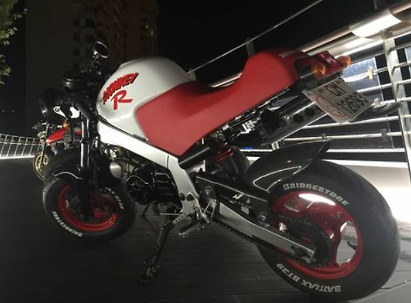 Motorcycle with a red seat and visible branding on a dark background