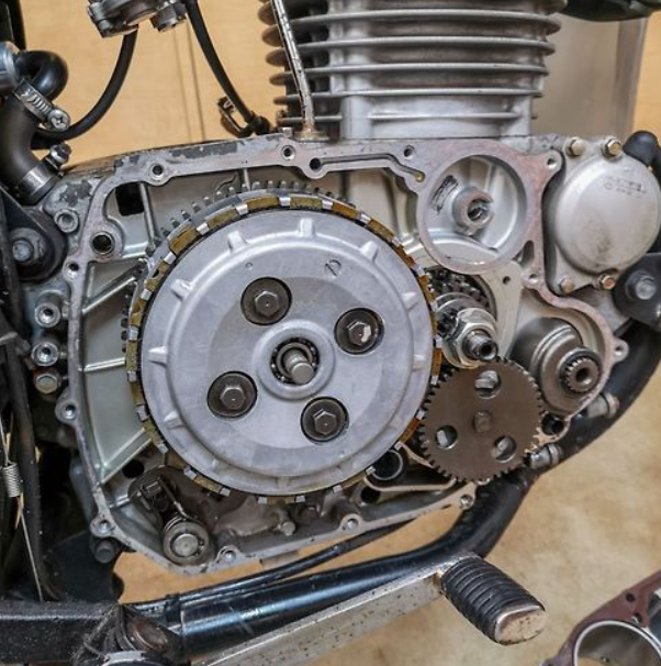 Close-up of a motorcycle engine with gears and mechanical components.
