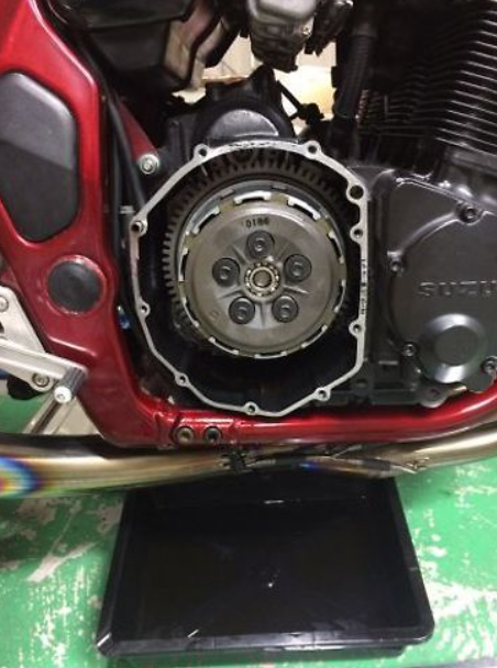 Close-up of a motorcycle engine with a visible brand logo on a green surface.