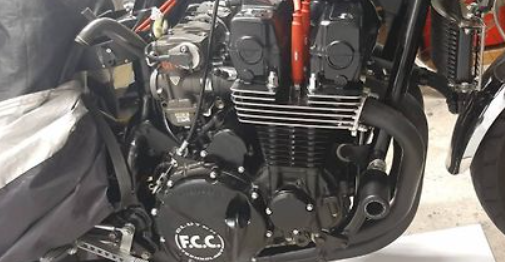 Close-up of a motorcycle engine with 'FCC' branding.