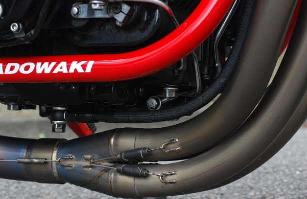 Close-up of a motorcycle exhaust with 'Kawasaki' branding.