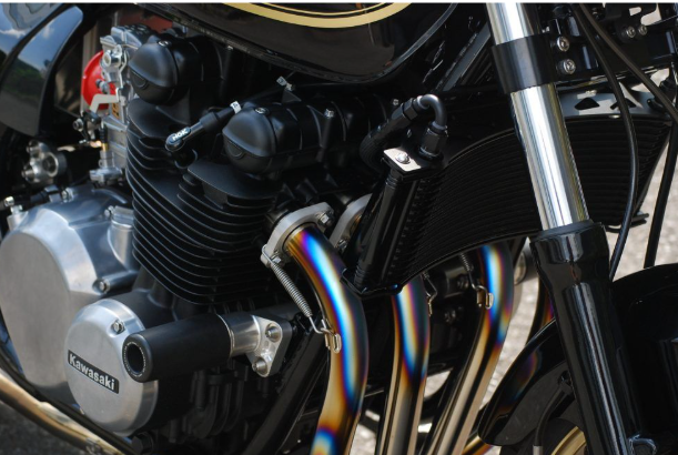 Close-up of a motorcycle engine with chrome exhaust pipes.