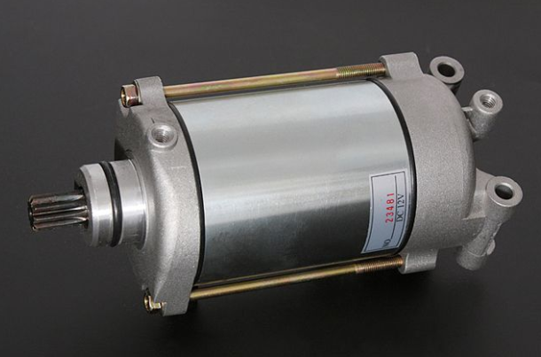 Metallic cylindrical component with shaft on a dark background