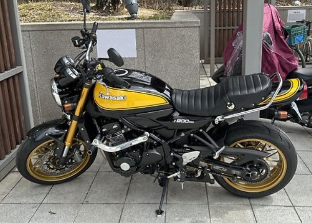 Black and yellow Kawasaki motorcycle parked on a tiled floor.