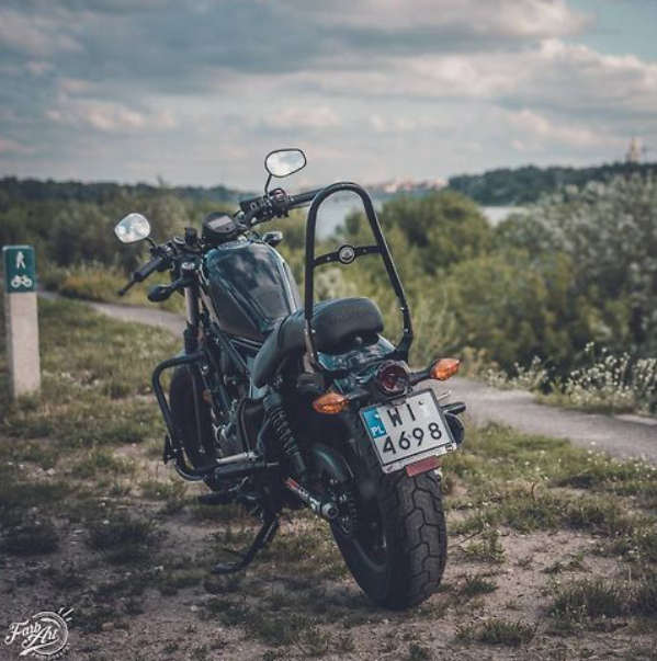 Motorcycle parked on a dirt road with a scenic background