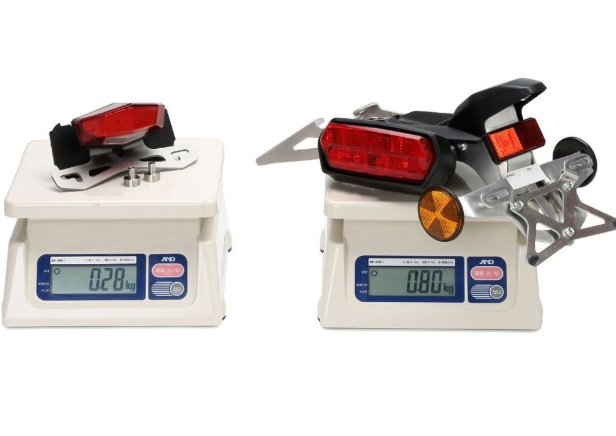 Two digital scales with motorcycle taillights on a white background