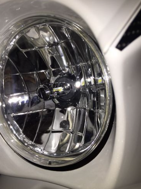 Close-up of a car headlight with a shiny metallic finish.
