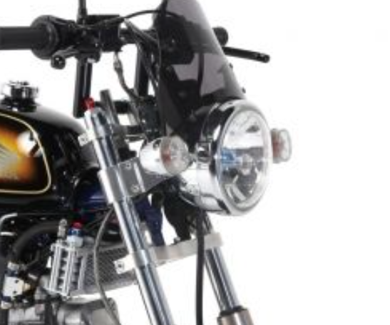 Close-up of a motorcycle's headlight and handlebar on a white background
