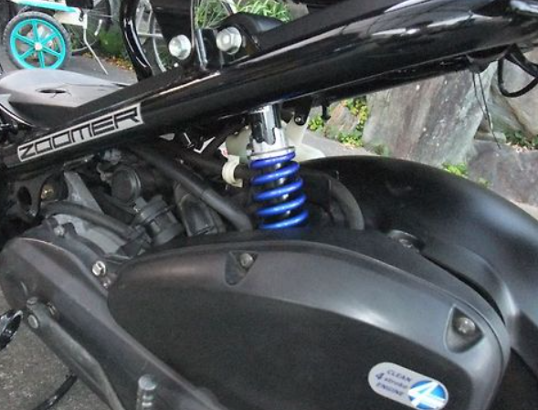 Close-up of a motorcycle suspension system with 'Zumler' branding.