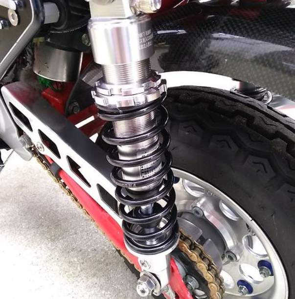Close-up of a motorcycle suspension system with a chain and wheel.