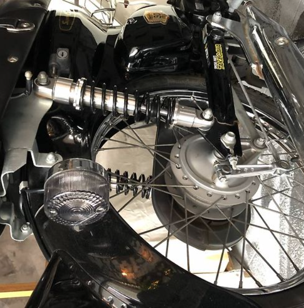 Close-up of a motorcycle's front wheel and suspension system.