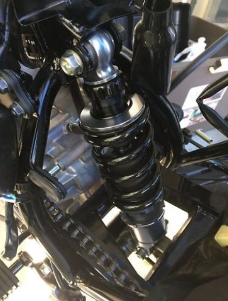 Close-up of a motorcycle suspension system with shiny metal components.