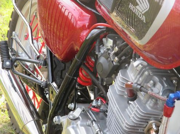 Close-up of a Honda motorcycle engine and exhaust system.