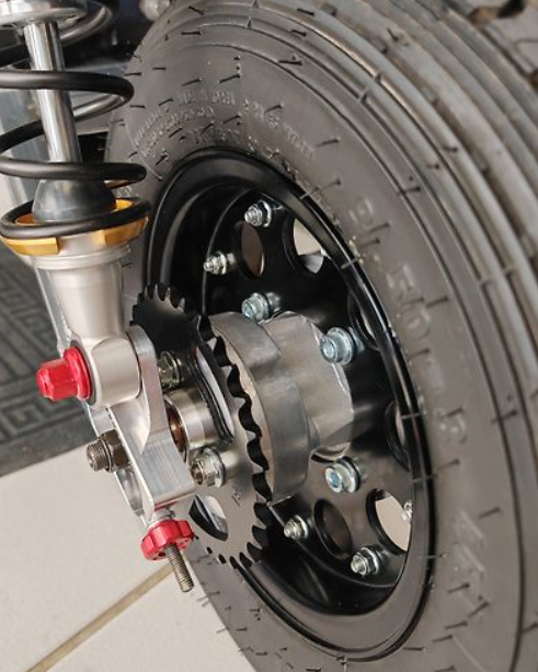 Close-up of a motorcycle wheel with suspension and chain mechanism.