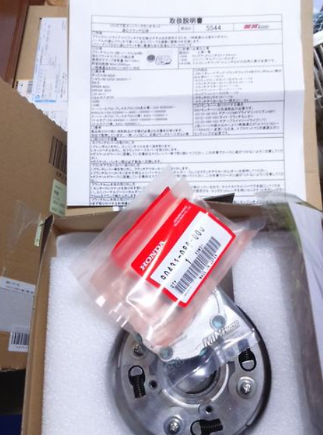 Honda engine part in packaging with a box and documentation in the background