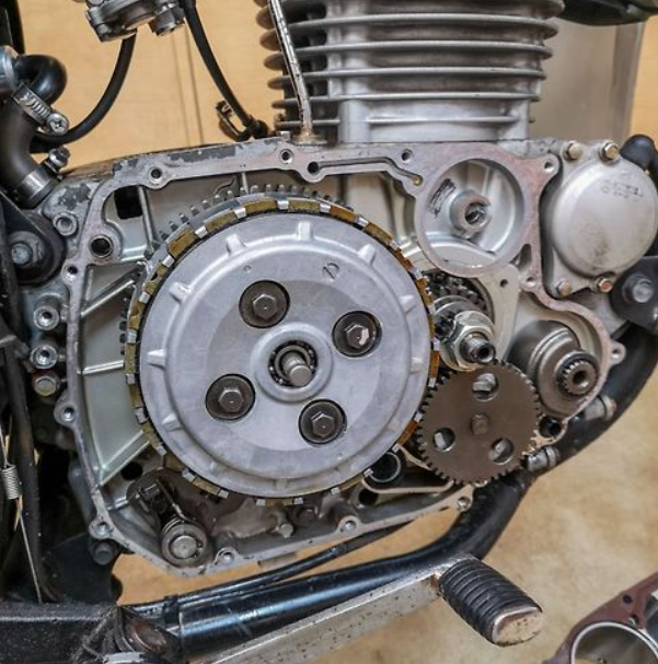Close-up of a motorcycle engine with gears and mechanical components.