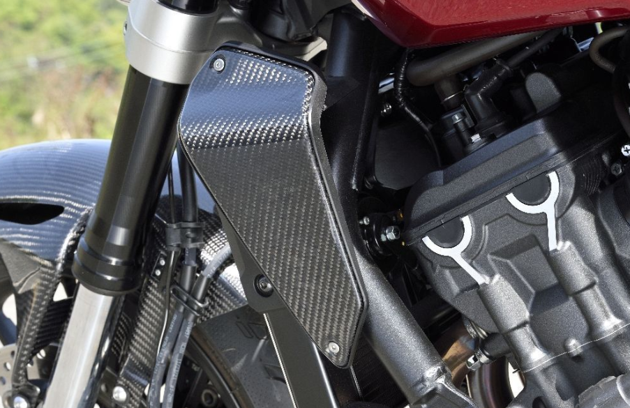 Close-up of a motorcycle's carbon fiber engine cover with blurred background
