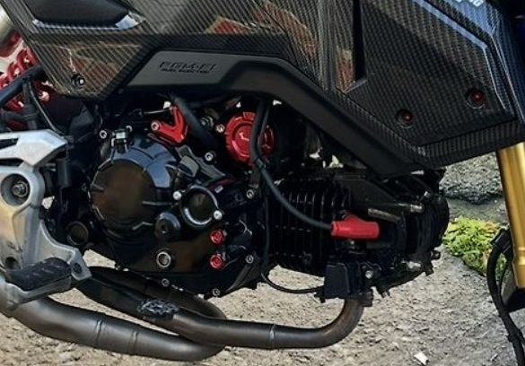 Close-up of a motorcycle engine with visible branding on a textured surface.