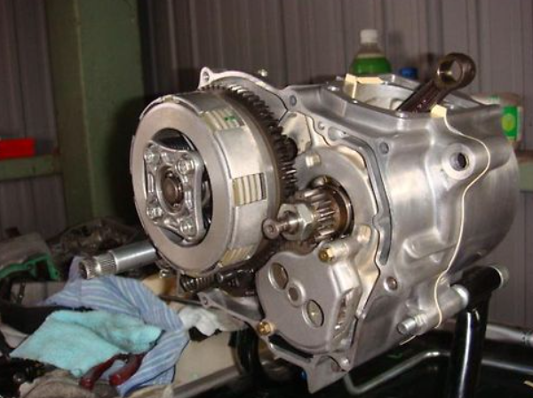 Mechanical engine component on a stand with tools and parts in the background