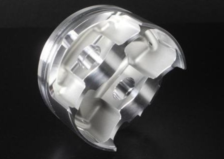 Metallic cylindrical component with cutaway design on a black background