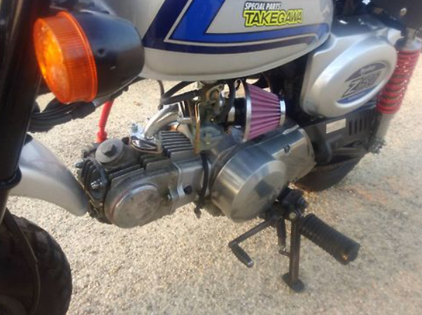 Close-up of a motorcycle engine with visible branding on a textured surface
