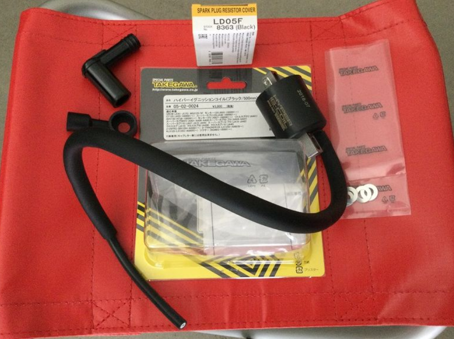 Red bag with black strap and warning label on a gray surface