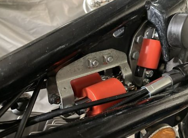 Close-up of a mechanical component with red and black parts on a vehicle.