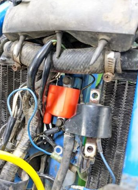Close-up of a motorcycle engine with visible wiring and components.