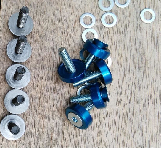 Blue screws and washers on a wooden surface