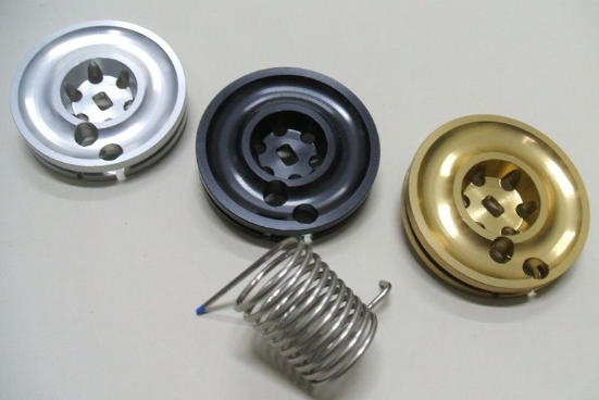 Four metal components on a light gray background
