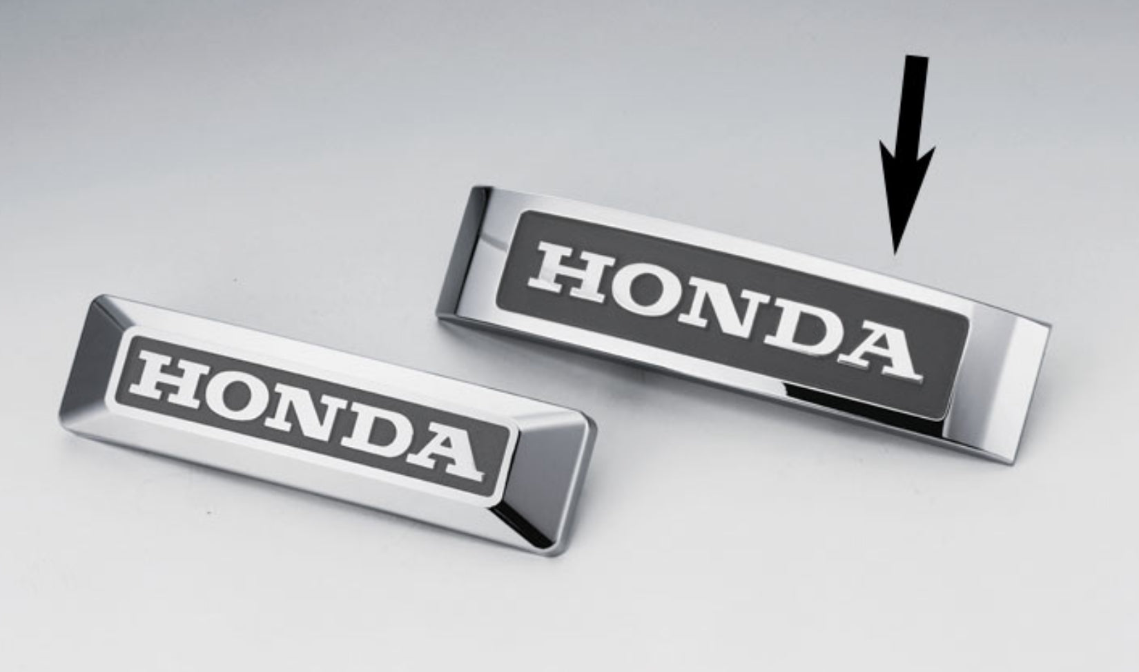Two Honda emblems on a light gray background