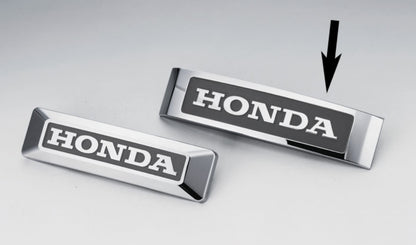 Two Honda emblems on a light gray background