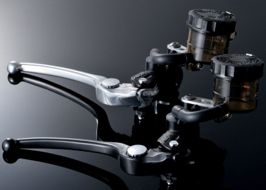 Close-up of motorcycle brake levers on a reflective surface with a dark background