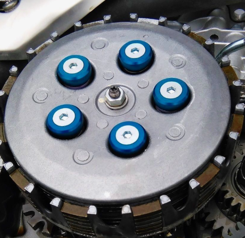 Close-up of a mechanical component with blue buttons and gears in the background