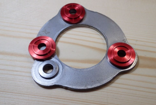 Metallic washer with red washers on a wooden surface