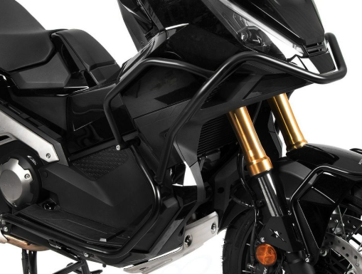 Close-up of a black motorcycle with gold suspension forks on a white background