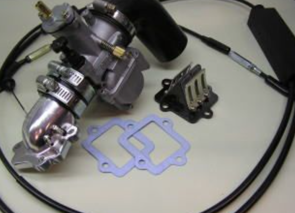Mechanical parts including a carburetor and gaskets on a white surface